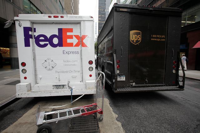 UPS and FedEx truck parked side by side in New York City.